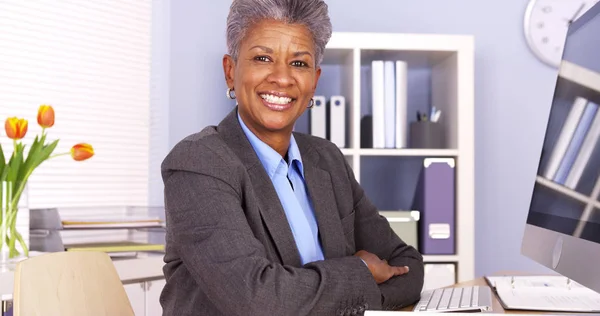 Μαύρο Επιχειρηματίας Που Κάθεται Στο Γραφείο Χαμογελώντας — Φωτογραφία Αρχείου
