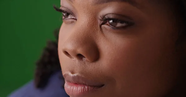 Close up of lovely black woman\'s face as she looks off screen on green screen