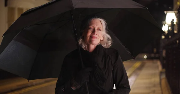 Gelukkig Oudere Vrouw Permanent Onder Paraplu Een Regenachtige Avond Stad — Stockfoto