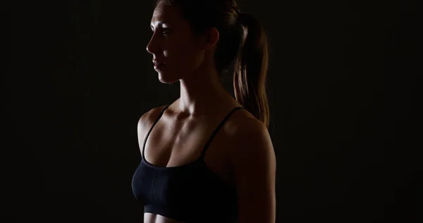 Healthy mixed race woman standing black background