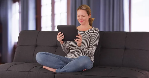 Mulher Branca Sentada Sofá Por Janela Com Cortinas Usando Tablet — Fotografia de Stock