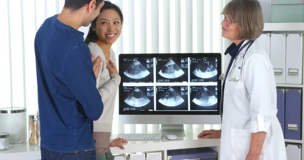 高级医生对异国情侣谈怀孕扫描 — 图库照片