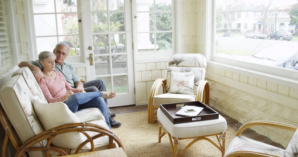 Mature couple sitting and writing in journal