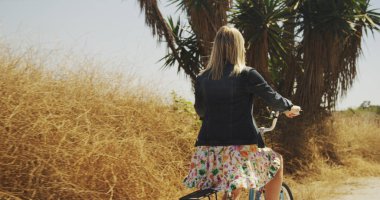 Hipster Genç beyaz beyaz kız tozlu bir iz üzerinde bisiklete binmek