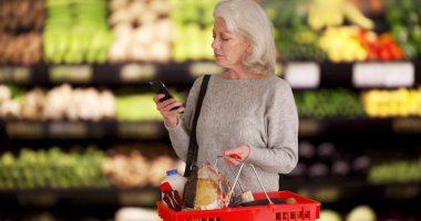 Olgun beyaz Bayan üretmek bakkallar smartphone kontrol bölümü