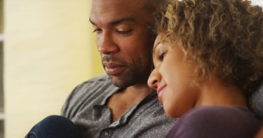 Siyah çift kanepe gülümseyerek oturan