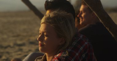 Dalgaları seyretmekten sahilde oturan güzel çiftler