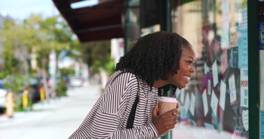 Sevimli siyah kadın kahve içme ve pencere ekrana bakarak çizgili top