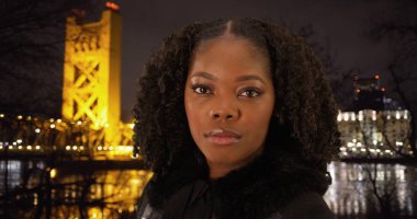 Oldukça siyah kadın kamera tarihi köprü arka planda bakarak yakın çekim