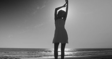 Çekici kadın beyaz elbiseli sahilde dans