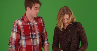 Genç kadın erkek yeşil ekranda tarafından standları iken çantasını arıyor