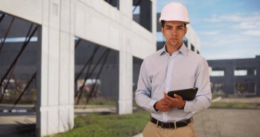 Genç yakışıklı mimar modern tablet holding inşaat sahasında