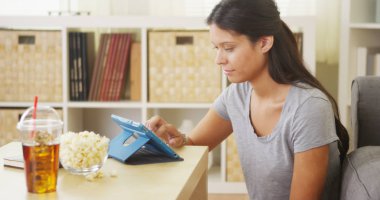 Kahve masasının üstüne tablet kullanan karma yarış kadın