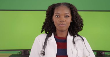 Ekranda yeşil ekranlı bilgisayarlar tarafından oturan başarılı siyah kadın doktor