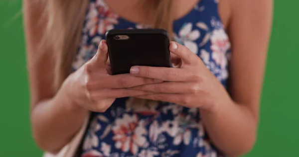グリーン バックに携帯電話とメッセージの若い女性の手のクローズ アップ — ストック写真