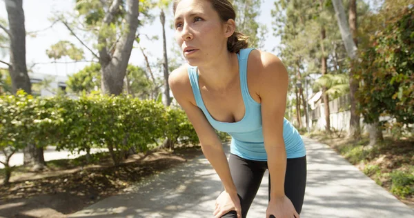 Healthy mixed ethnic woman taking break from jog