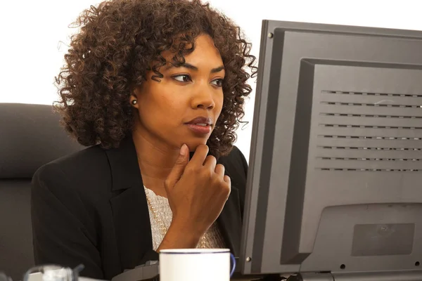 Young African business woman looking at computer screen