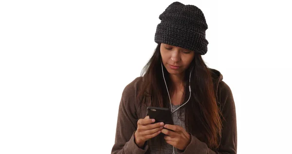 Millennial girl listens to music streaming app with smartphone white background