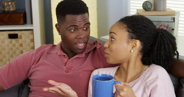 年轻的黑人妇女喝茶 并在沙发上与男友聊天 — 图库照片