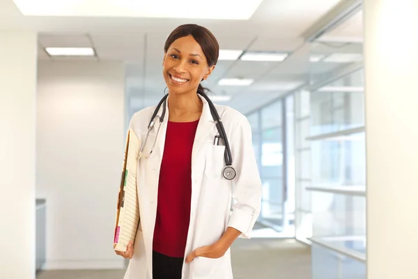 Happy young black doctor smiling at camera indoors health clinic