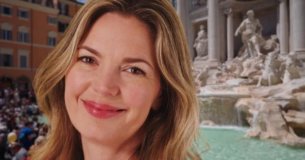 Caucasian woman at the Trevi Fountain laughing and smiling