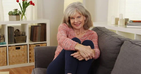 Mature Woman Sitting Couch Smiling — Stock Photo, Image