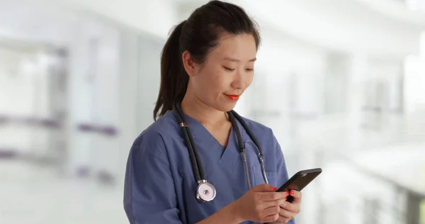 Feliz Joven Médico Asiático Matorrales Mensajes Texto Con Teléfono Inteligente —  Fotos de Stock