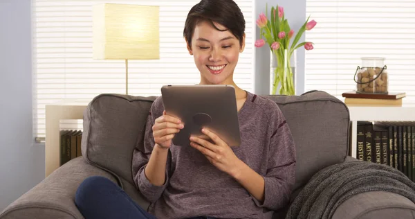 アジアの女性がソファにタブレットを使用して — ストック写真