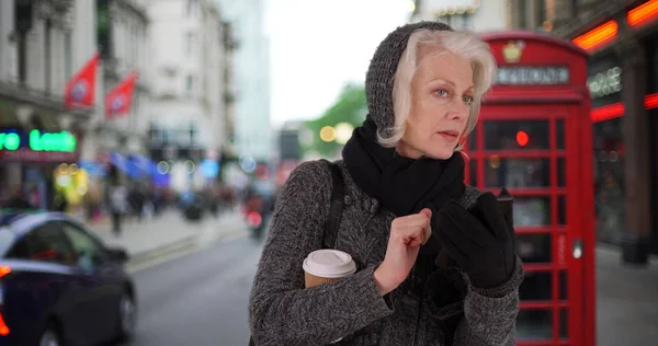 Senior Vrouw Vakantie Londen Wachten Voor Rideshare Met Mobiele Telefoon — Stockfoto