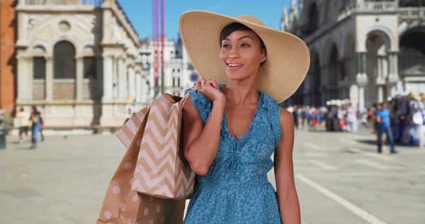 时尚的黑人女子站在威尼斯圣马克广场拿着购物袋 — 图库照片