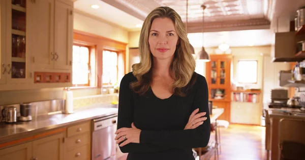 Blonde female standing in contemporary kitchen