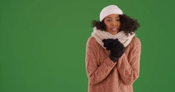 穿着冬衣站在绿色屏幕上的年轻黑人妇女 — 图库照片