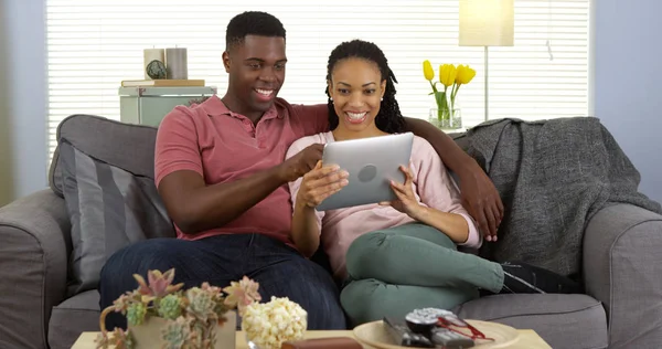 Uśmiechnięta Młoda Para Czarny Przy Użyciu Komputera Typu Tablet Kanapie — Zdjęcie stockowe