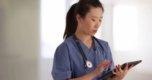 在医院内使用便携式平板电脑的专业年轻医生或护士 — 图库照片