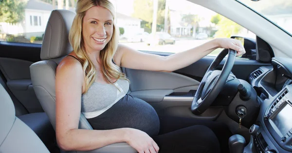 美丽的怀孕妇女坐在汽车微笑 — 图库照片
