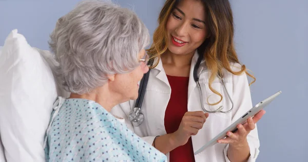 成熟した女性患者と話しているタブレットを使用して日本の医師 — ストック写真