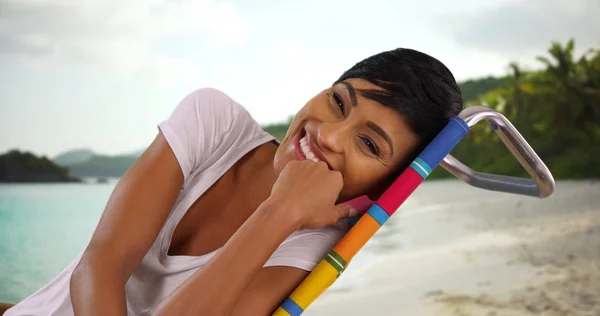 年轻黑人女性的肖像坐在加勒比海海滩上与镜头交谈 — 图库照片