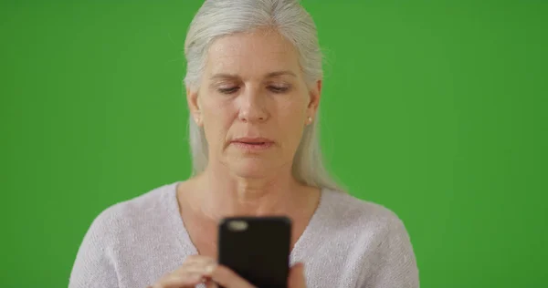Eine Ältere Frau Mit Ihrem Smartphone Auf Dem Grünen Bildschirm — Stockfoto
