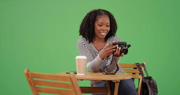 年轻的黑人女摄影师与相机坐在咖啡馆在绿色屏幕上 — 图库照片
