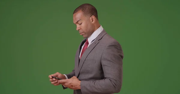 Afrikanischer Amerikanischer Geschäftsmann Blickt Auf Sein Handy Auf Grünem Bildschirm — Stockfoto