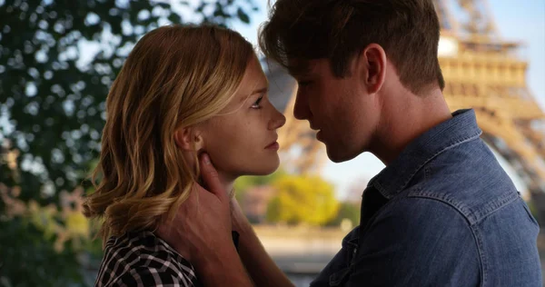 Young married couple in Paris gaze into each others eyes about to kiss