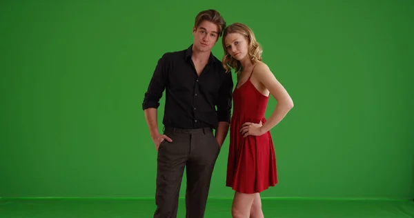 Portrait of young well-dressed Caucasian couple posing on green screen