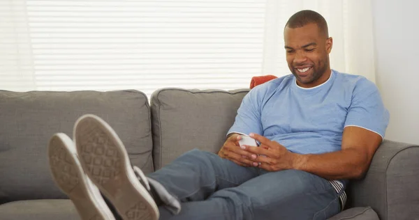 Schwarzer Mann Sitzt Auf Couch Sms Schreiben — Stockfoto