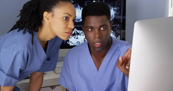 Female medical specialist working with colleague on computer