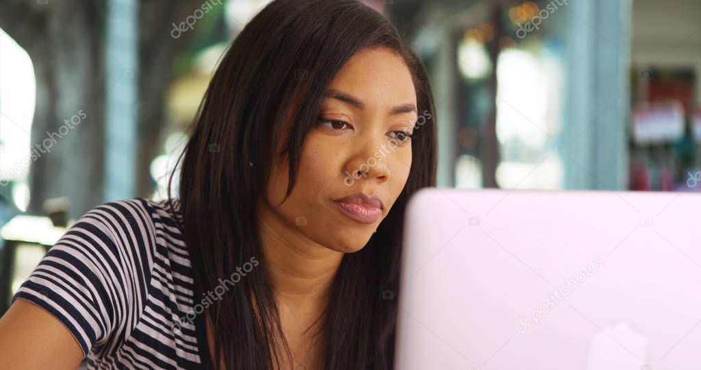 Portrait of black female working on laptop outdoor setting and talking
