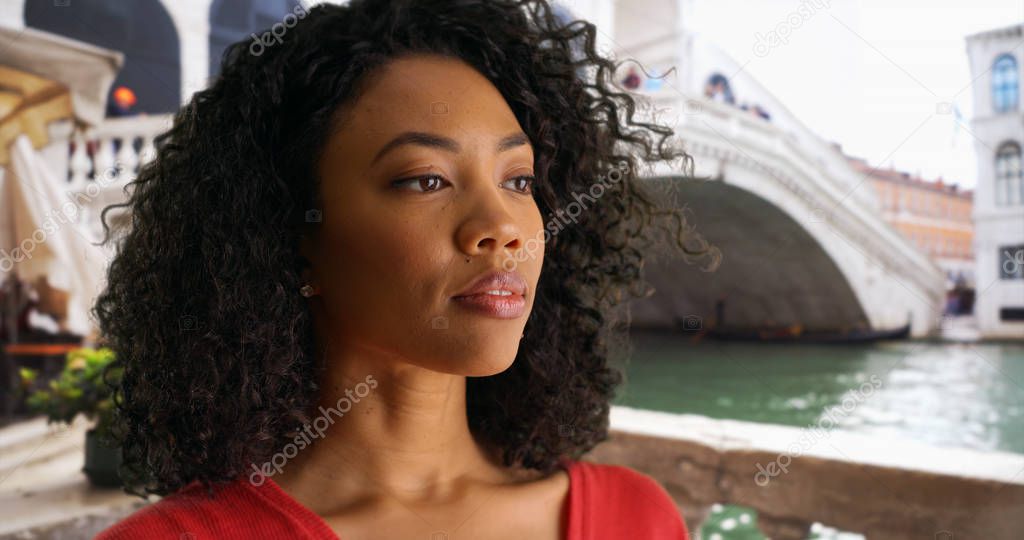 African-American girl thinking to herself and looking off-screen while in Venice