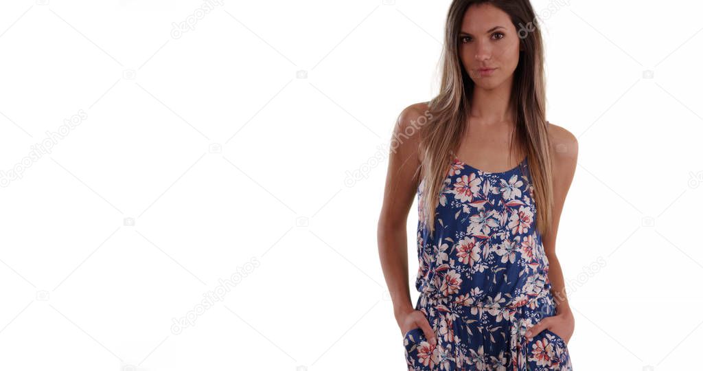 Pretty millennial woman in romper looking at camera on solid white background