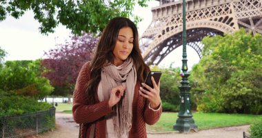 Smartphone cep telefonu ile Paris'te App kullanarak Sevimli Latina kadın