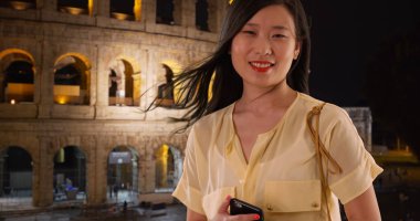 Çinli kadın turist Roma'da tatil sırasında Colosseum önünde gülümseyen