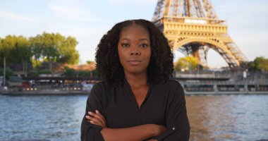 Eiffel Tower yakınındaki oldukça siyah kadın ayakta gülümseyen portresi
